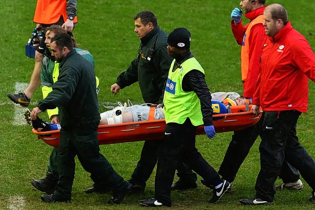 Saracens and England lock Geroge Kruis is stretchered off during yesterday's defeat to Harlequins with a suspected concussion