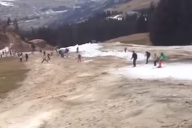 Skiers try and stay on the thin makeshift snow track