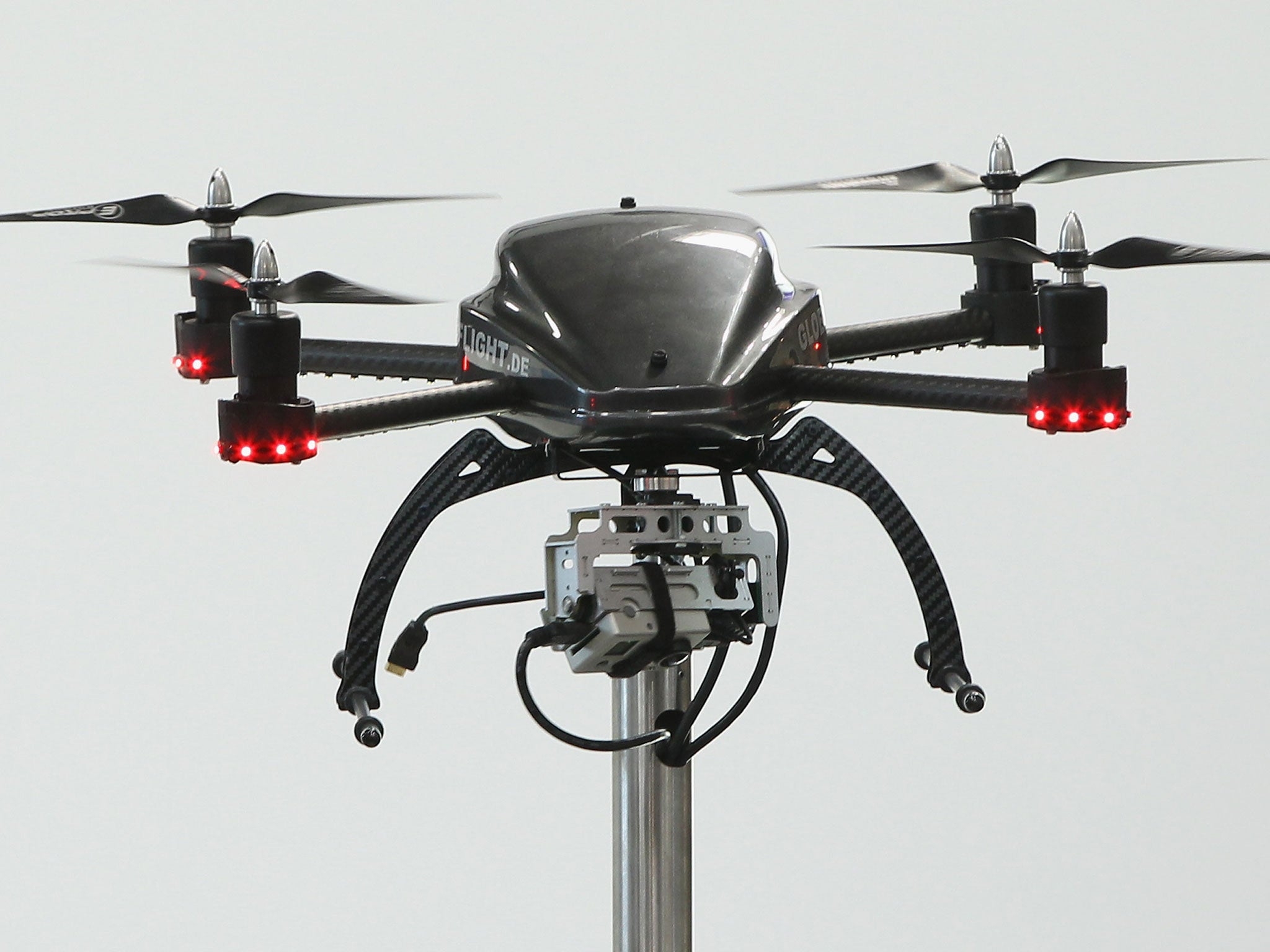 A quadrocopter drone equipped with a camera stands on display
