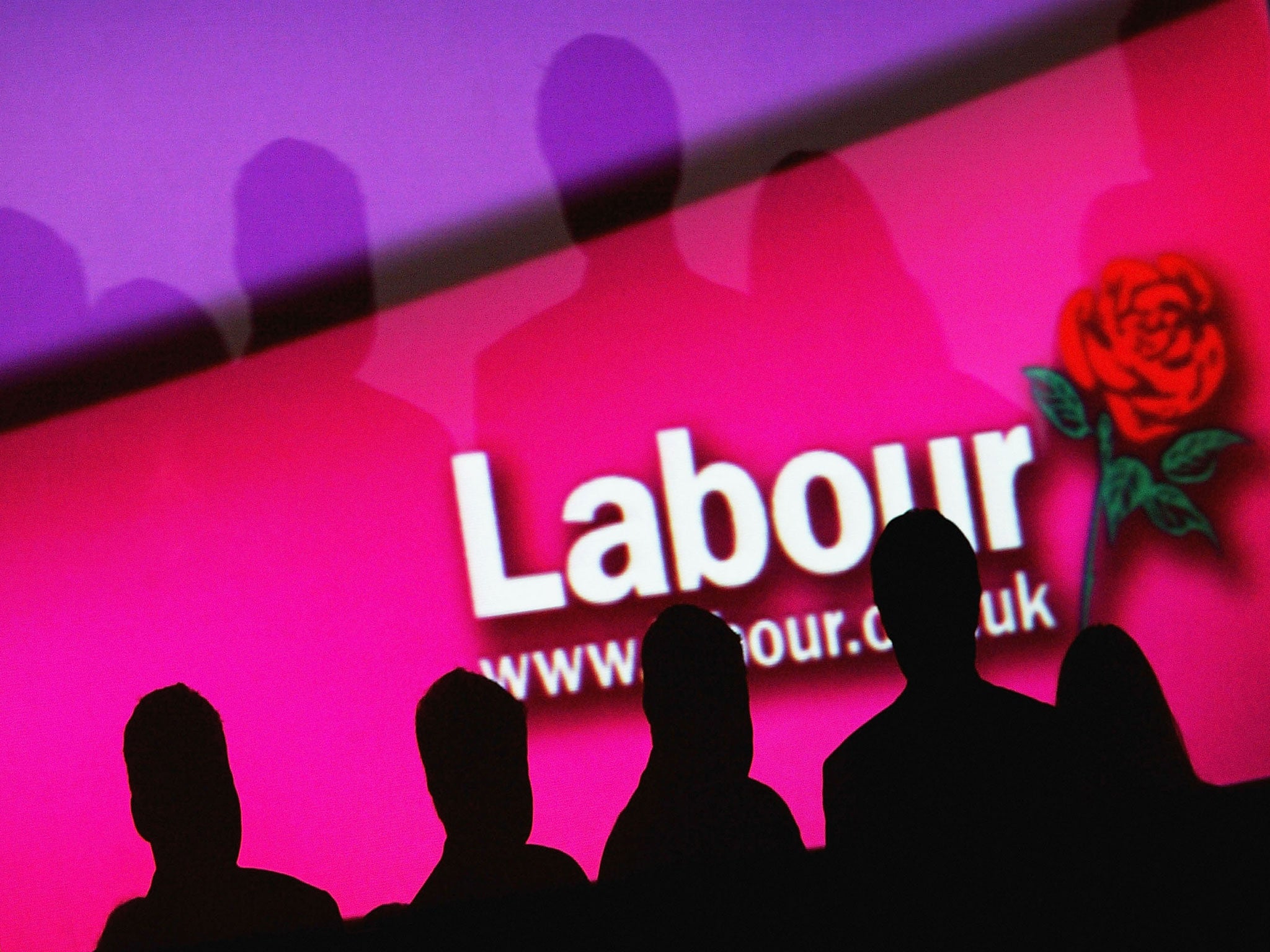 People are seen infront of a party logo during the Labour Party Annual Conference