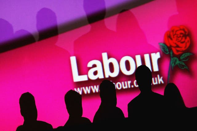 People are seen infront of a party logo during the Labour Party Annual Conference