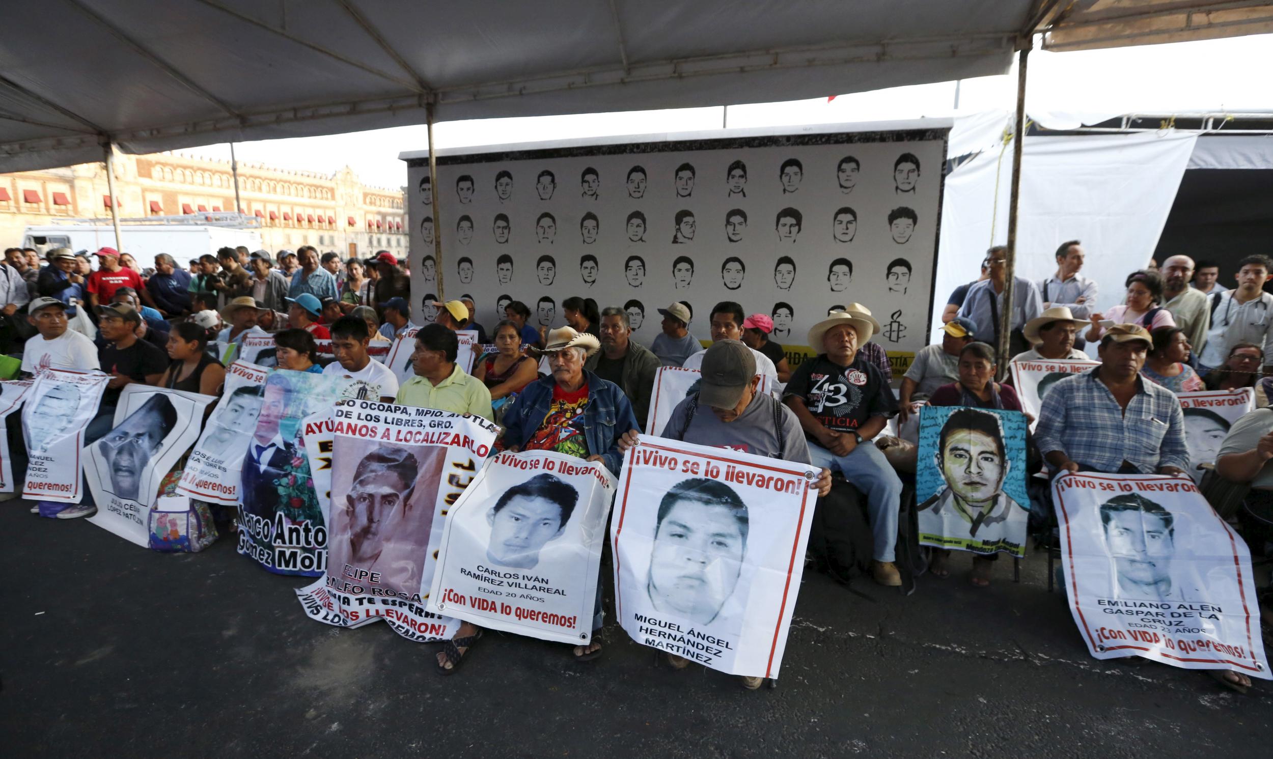 Relatives hold pictures of some of the 43 missing students during 48-hour hunger strike