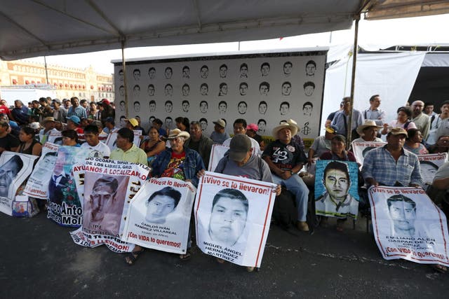 Relatives hold pictures of some of the 43 missing students during 48-hour hunger strike