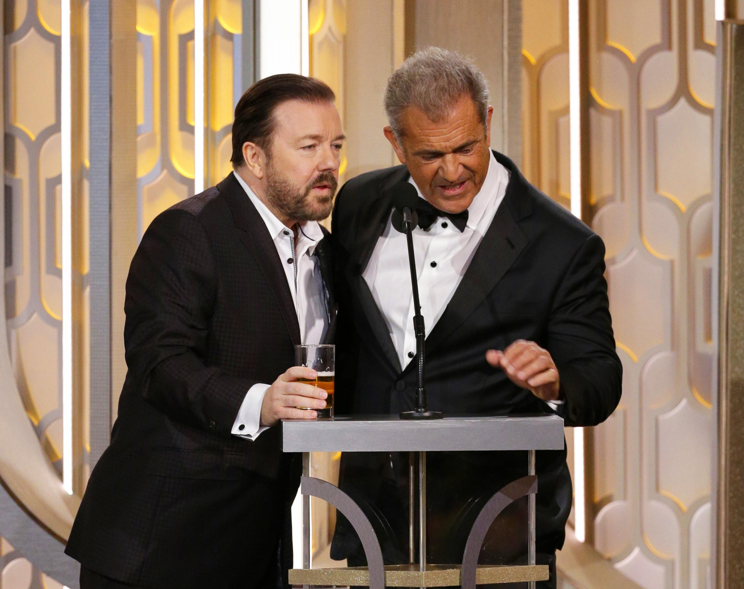 Host with the roast: Gervais interrupts Mel Gibson at the Golden Globes (AP)