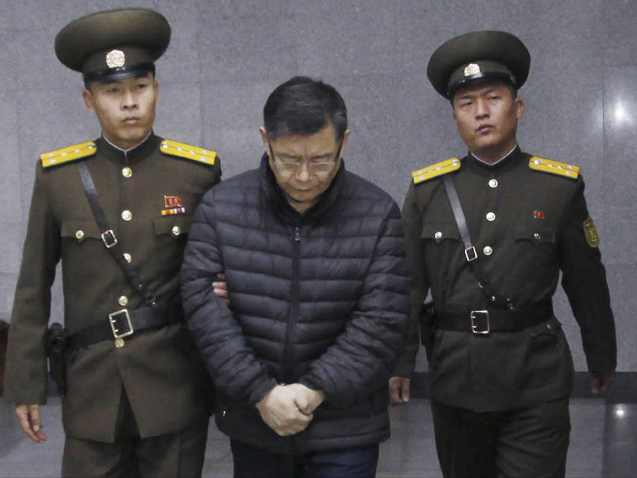 Hyeon Soo Lim, center being escorted to his sentencing in Pyongyang, North Korea in December