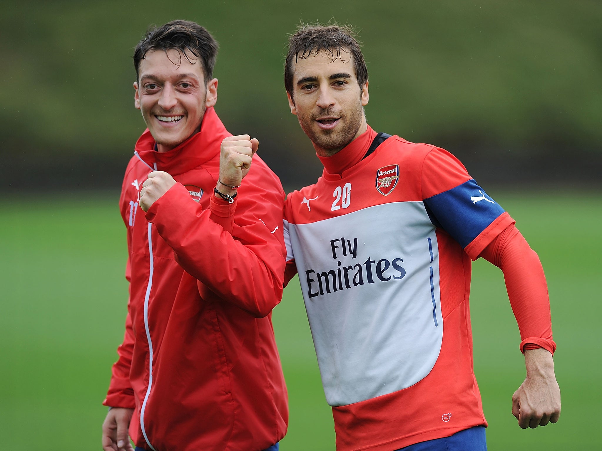 Mesut Ozil and Mathieu Flamini share a joke during training