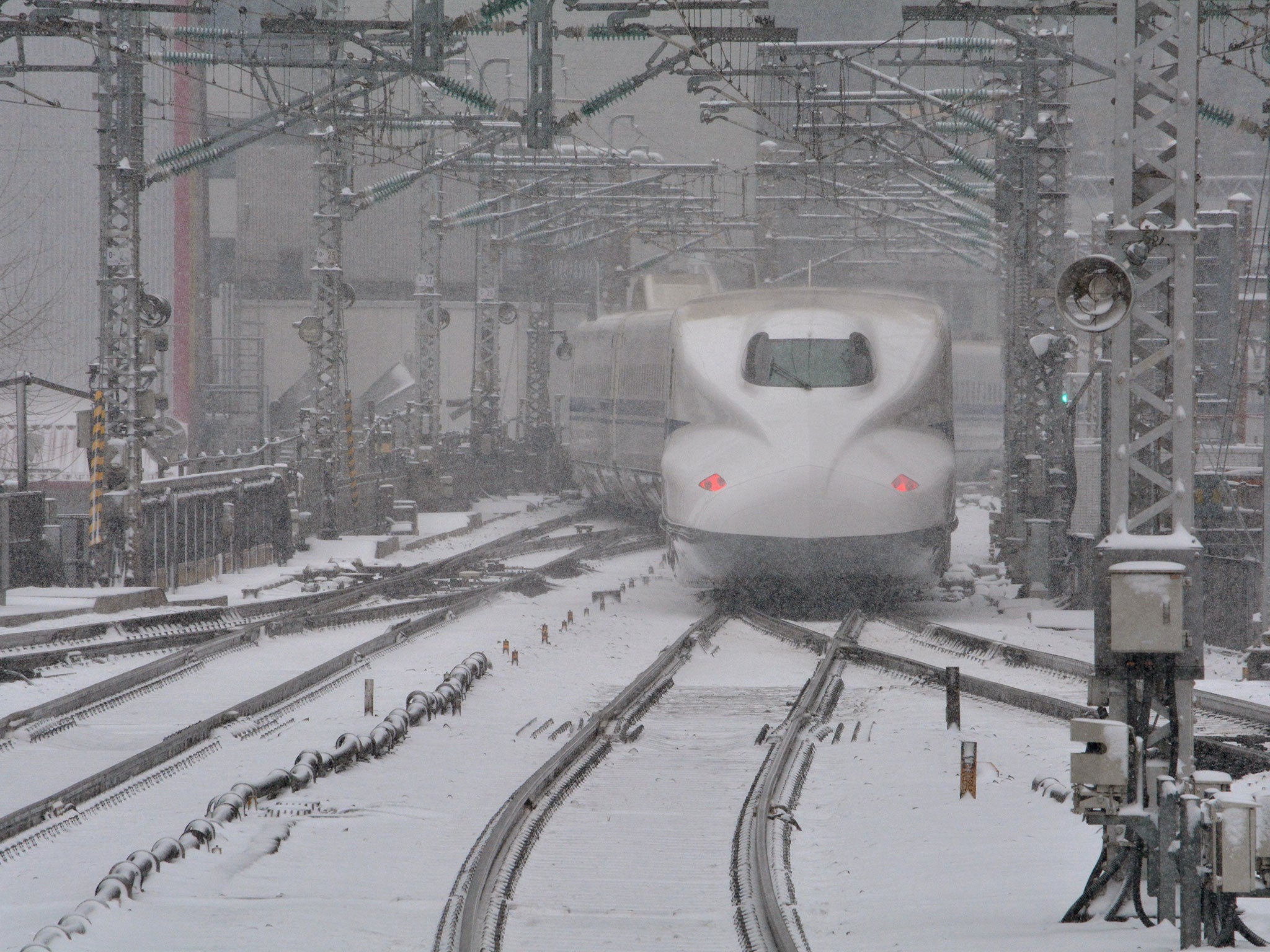 A bullet train leaves JR Tokyo Station in the snow on February 8, 2014