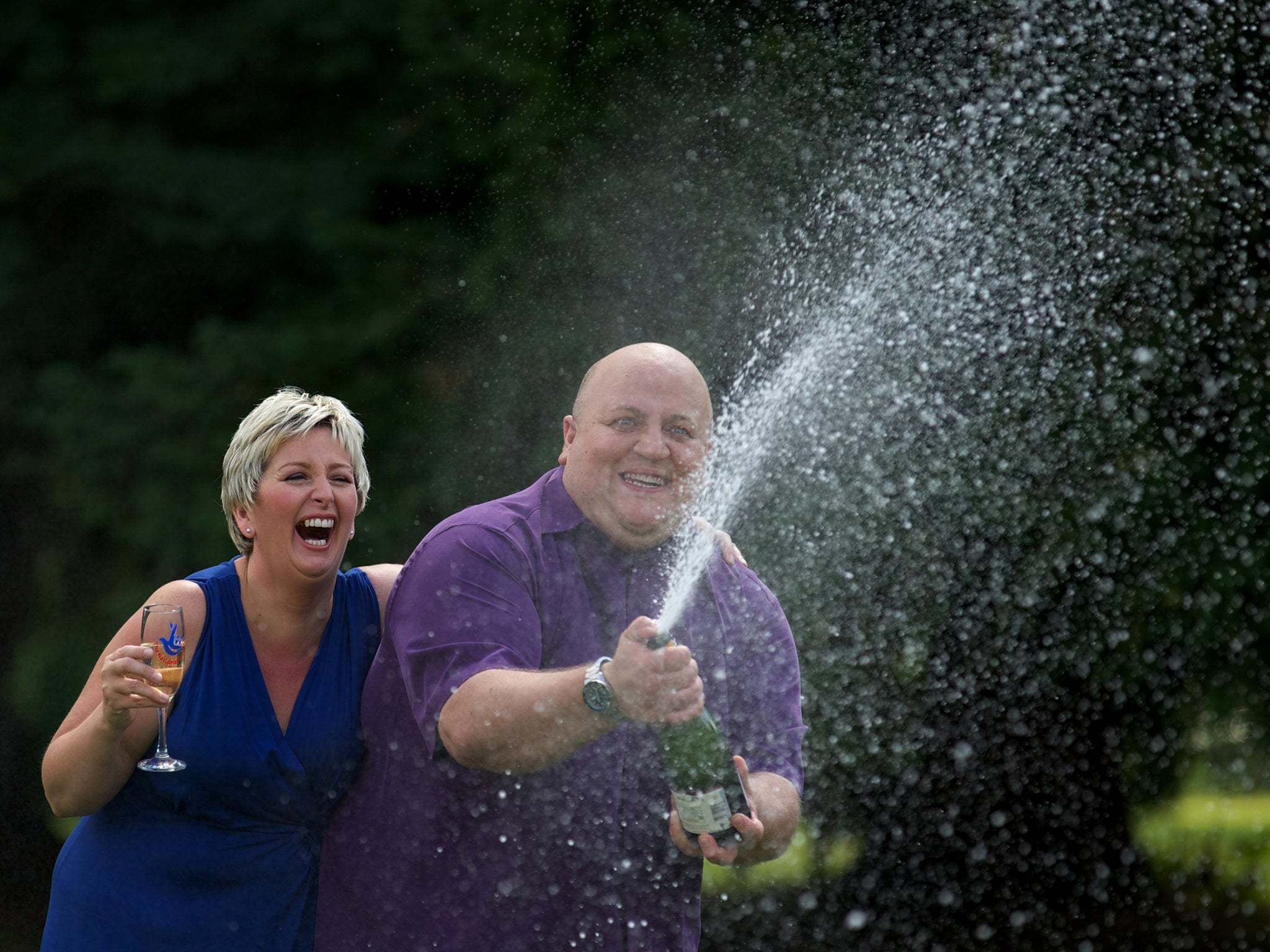 Adrian and Gillian Bayford spray champagne after winning more than £148 million on the EuroMillions