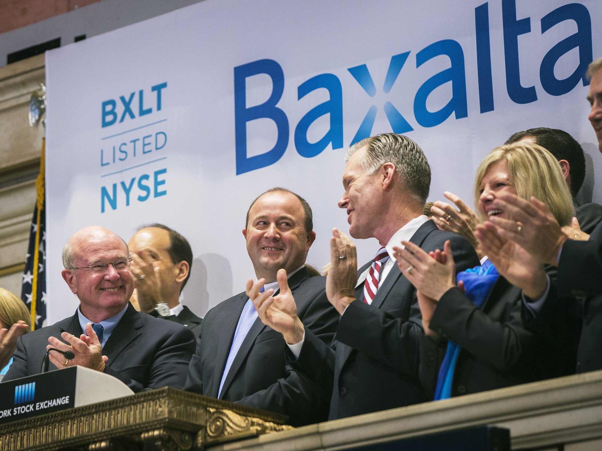 Ludwig Hantson, centre, CEO of Baxalta, celebrates the company's IPO after ringing the opening bell above the floor of the New York Stock Exchange in July last year