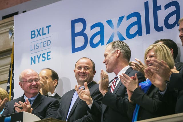 Ludwig Hantson, centre, CEO of Baxalta, celebrates the company's IPO after ringing the opening bell above the floor of the New York Stock Exchange in July last year
