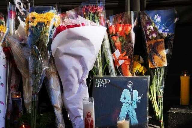 Flowers, candles and pictures are some of the items deposited at a memorial outside of the late musician and performer David Bowie's apartment that he shared with his wife in New York City