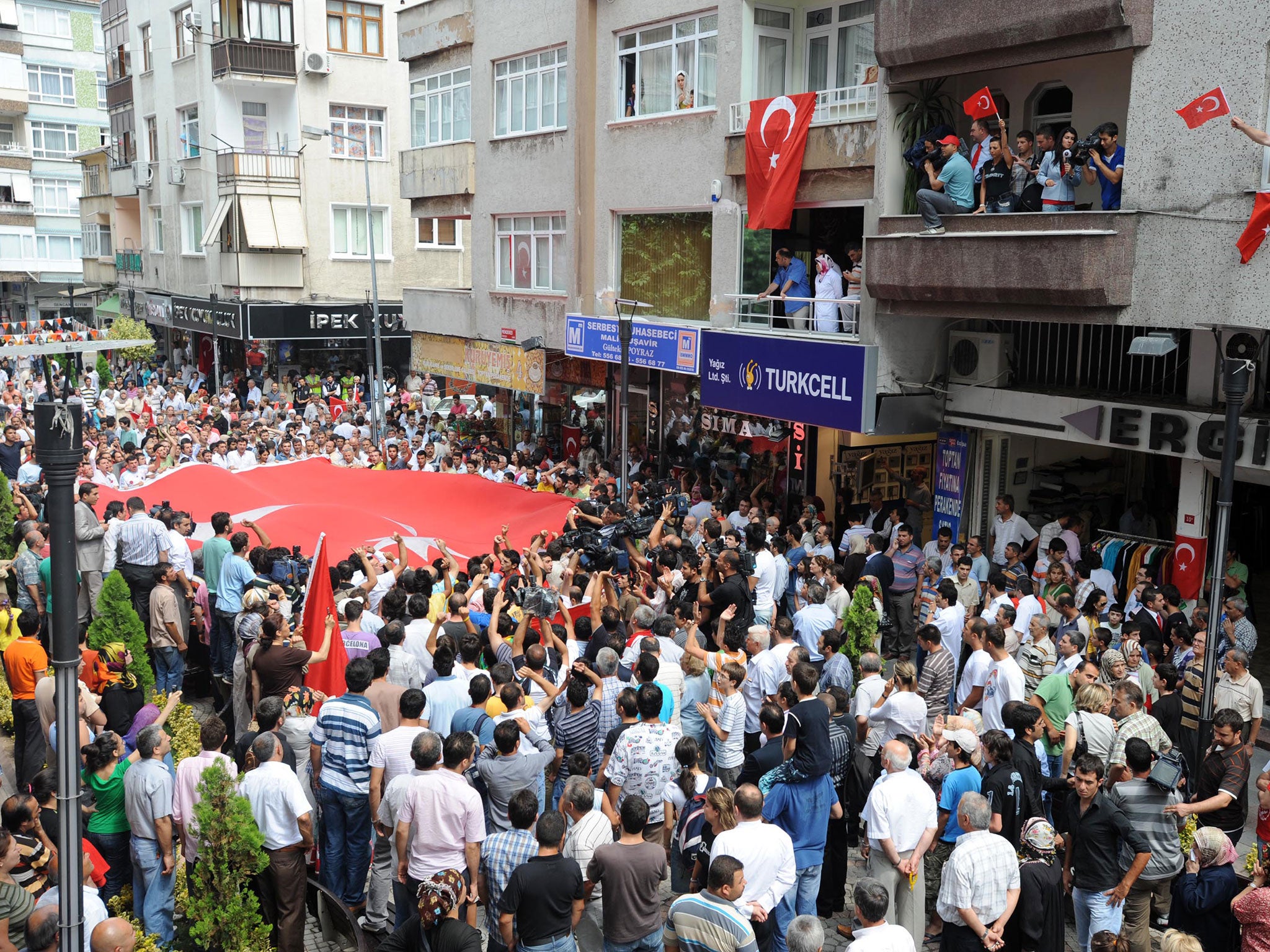 People carry Turkish flags at the blast scene, July 28, 2008 in Istanbul, Turkey.