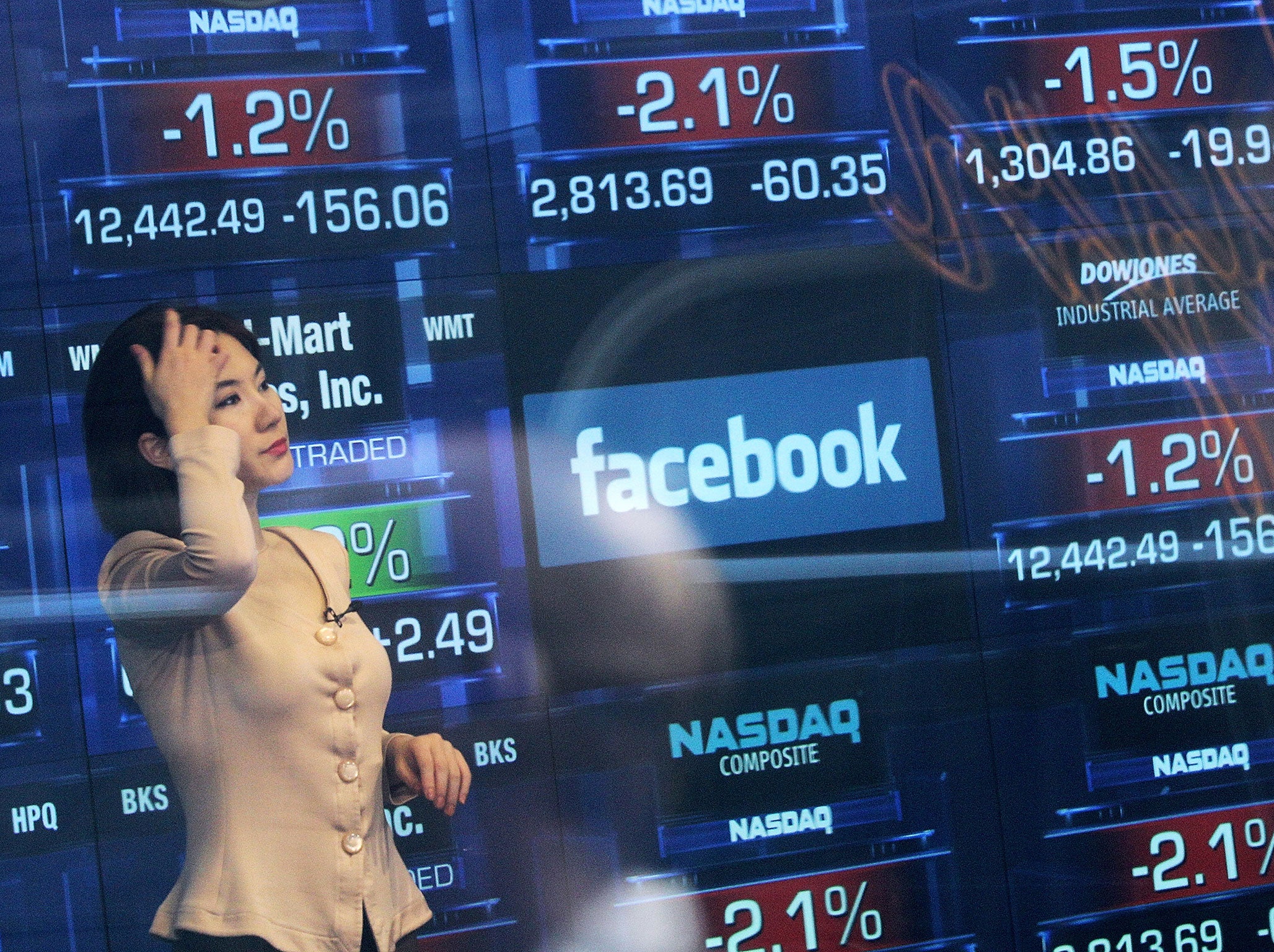A Nasdaq television reporter is seen inside the Nasdaq studios as the Facebook logo is displayed on a ticker board on May 17, 2012 in New York City