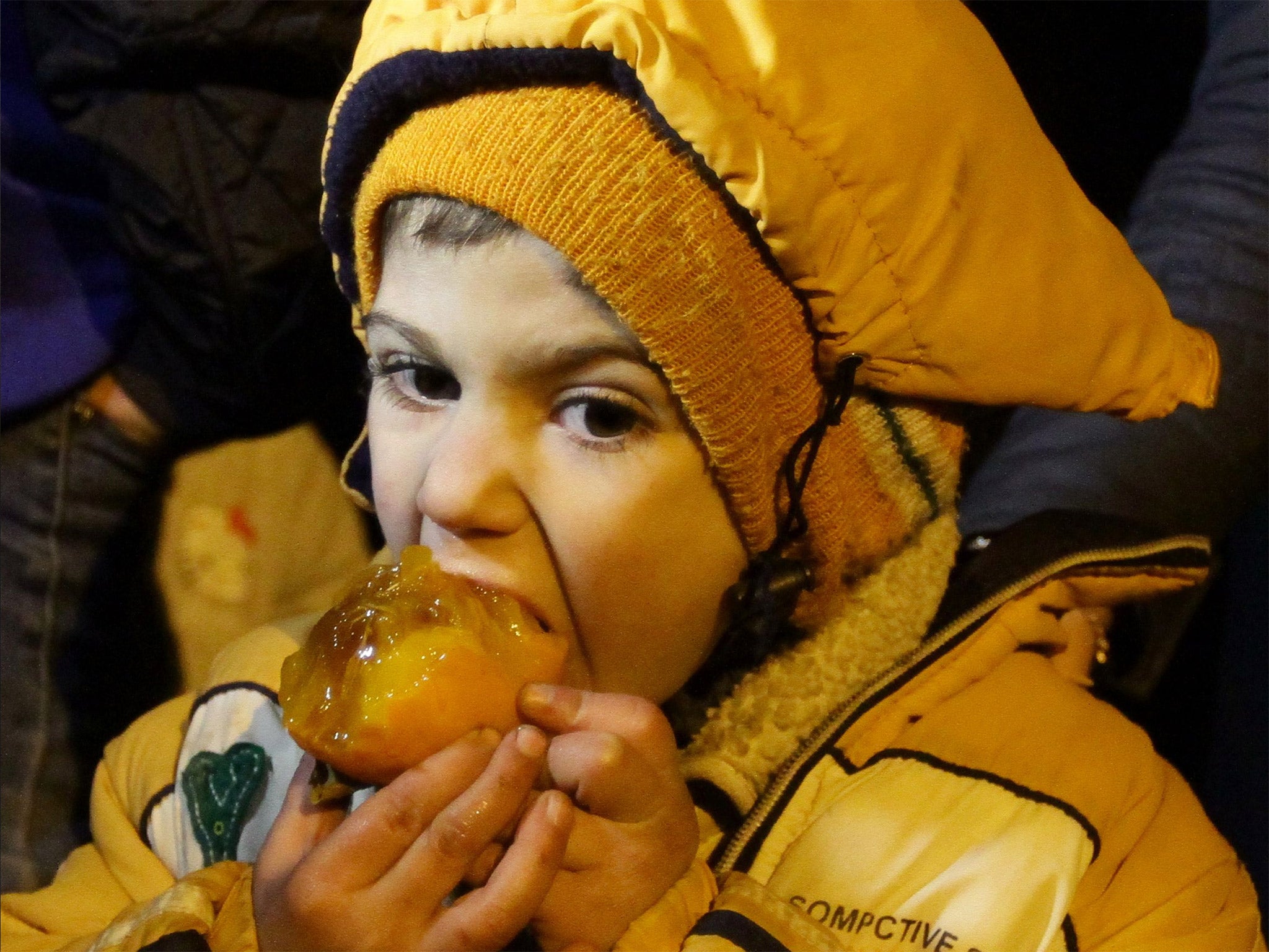 &#13;
A lucky child tucks into some fruit in Madaya &#13;