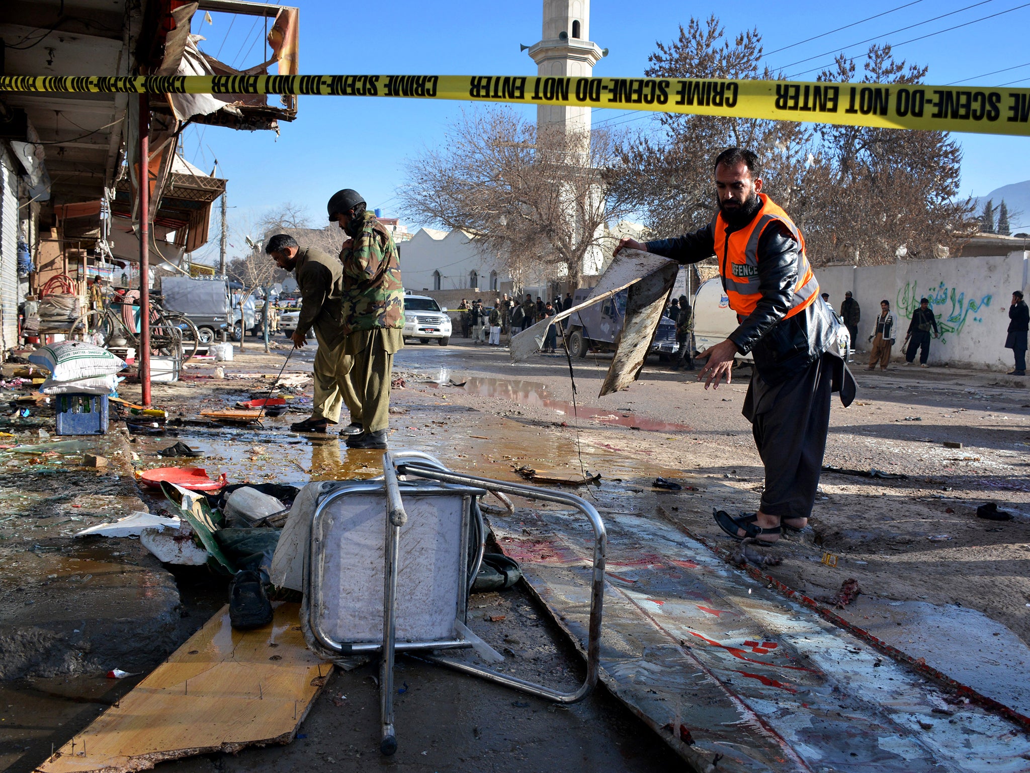 Pakistani security officials examine at the site of suicide bombing in Quetta, Pakistan. The suicide attack on a polio vaccination center in southwestern Pakistan killed more than a dozen people and wounded many, officials said.