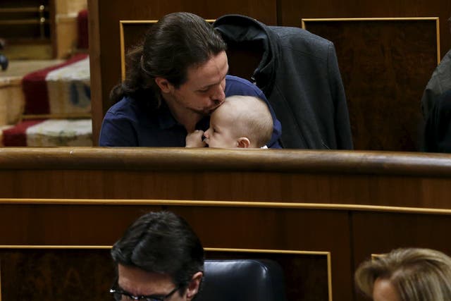 Podemos (We Can) party leader Pablo Iglesias kisses the infant son of  fellow party deputy Carolina Bescansa (not pictured) as parliament convened for the first time following a general election in Madrid, Spain