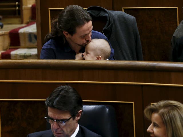 Podemos (We Can) party leader Pablo Iglesias kisses the infant son of  fellow party deputy Carolina Bescansa (not pictured) as parliament convened for the first time following a general election in Madrid, Spain