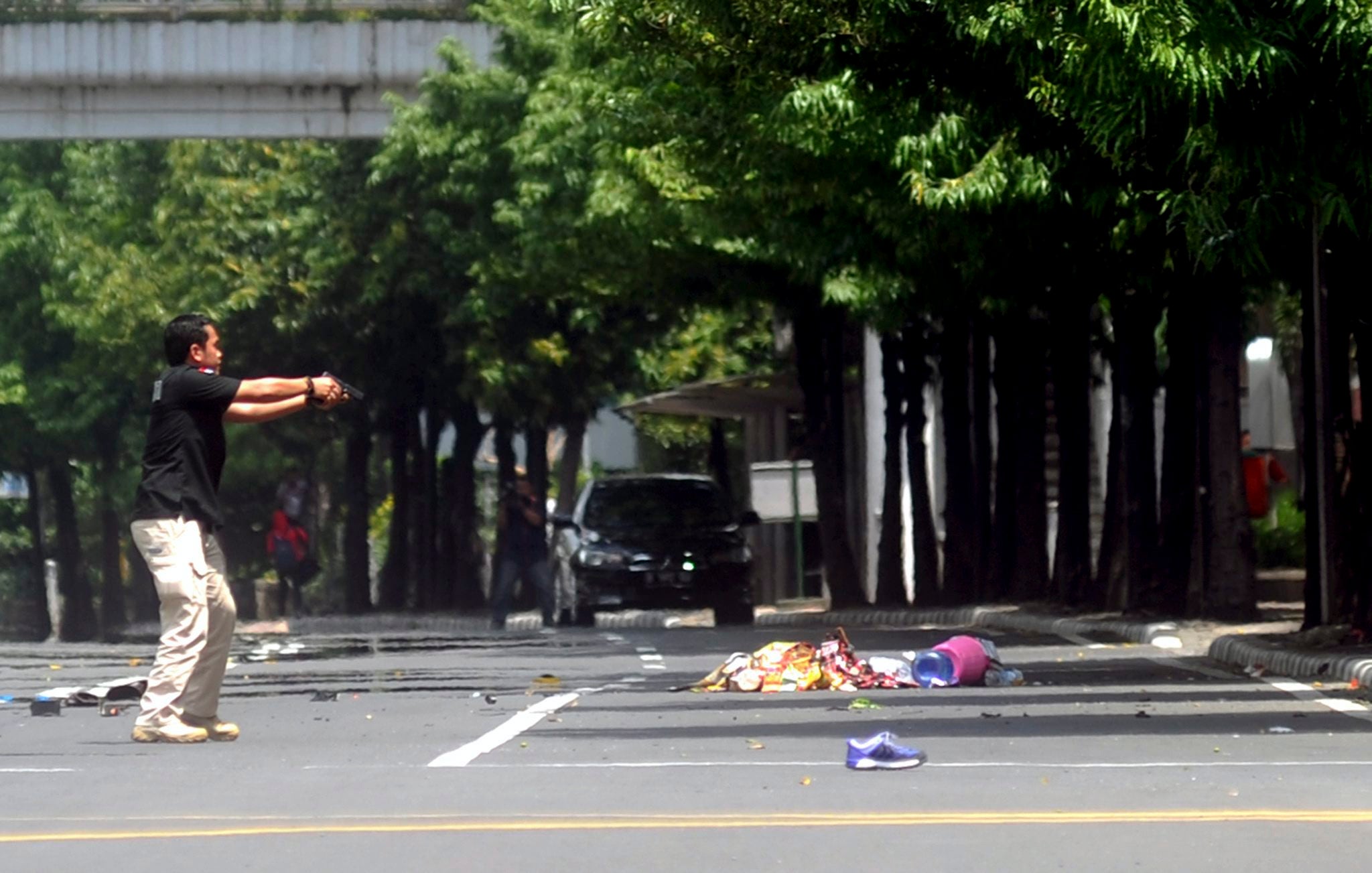 An armed Indonesian police officer points his gun as he secures the area