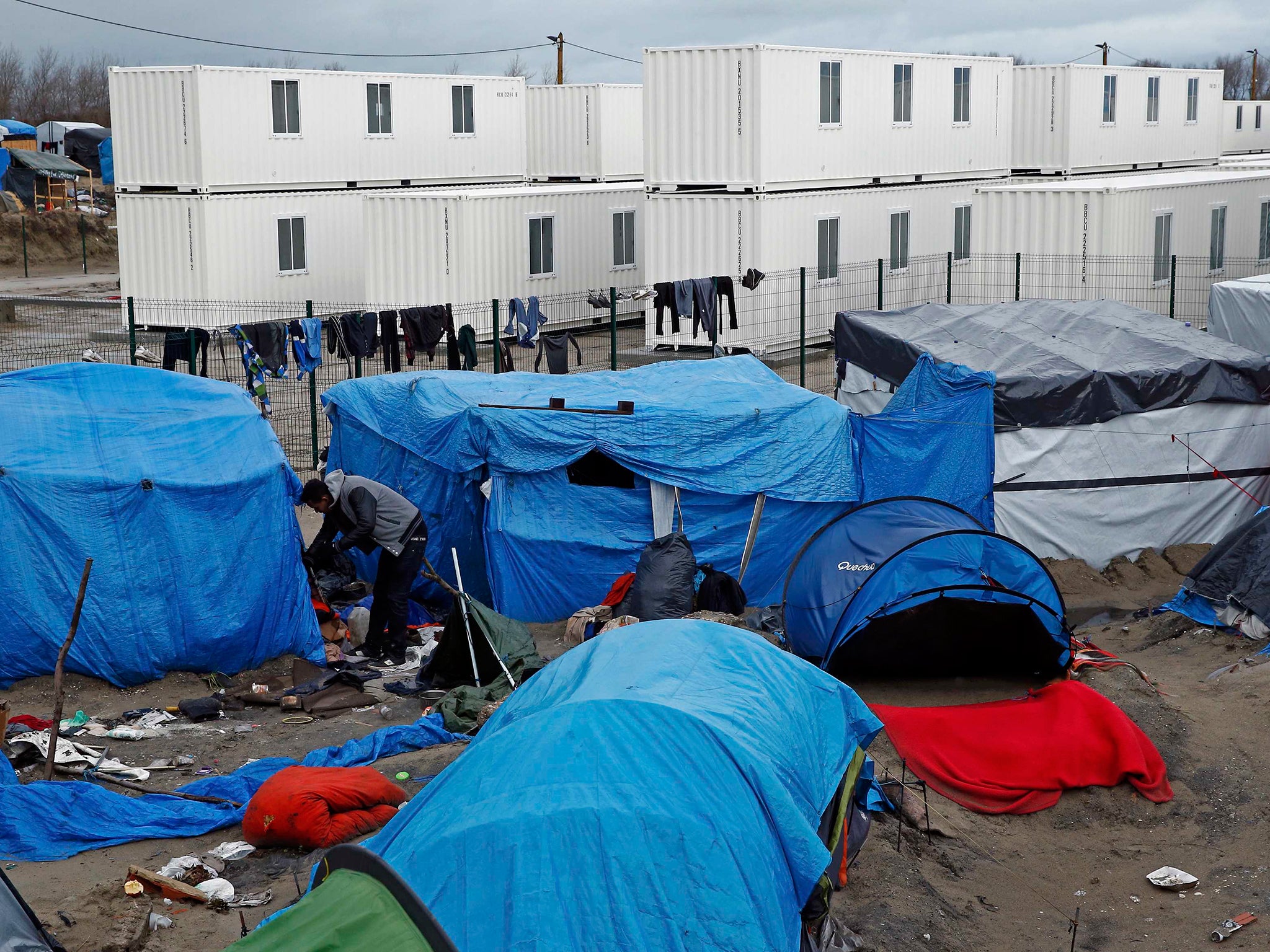 Containers (rear) have been put in place to house several hundred migrants living in what is known as the 'Jungle' - but it is not enough for the majority