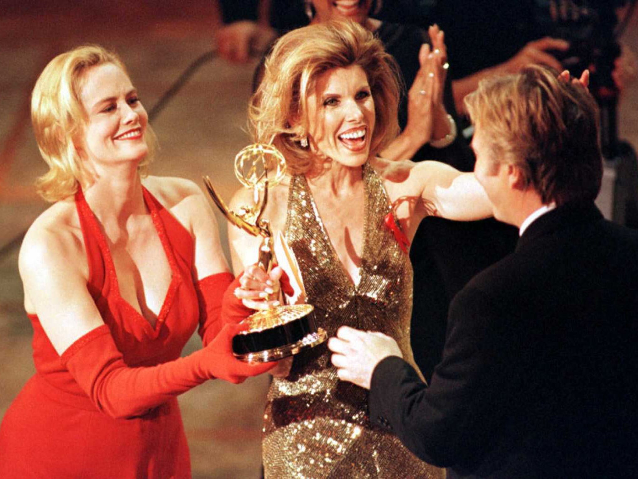 Actresses Cybill Shepherd (L) and Christine Baranski (C) present an Emmy to Alan Rickman (R) for outstanding lead actor in a mini-series or special for his lead role in the HBO production of 'Rasputin' during the 48th Annual Emmy Awards in Pasadena, California, 1996