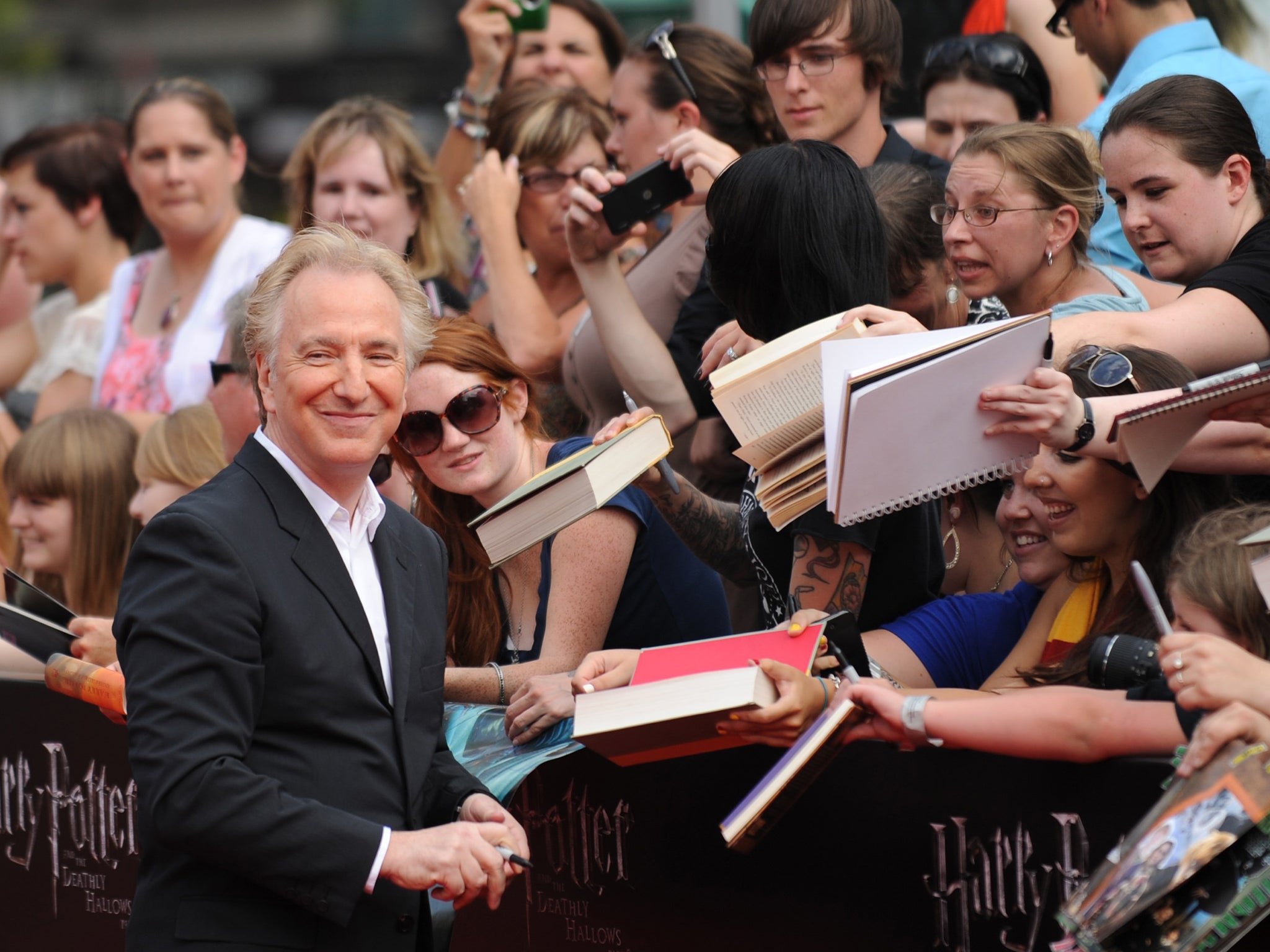 Alan Rickman signs autographs as he arrives for the North American premiere of Harry Potter and the Deathly Hallows Part 2 at Lincoln Center in New York, 2011