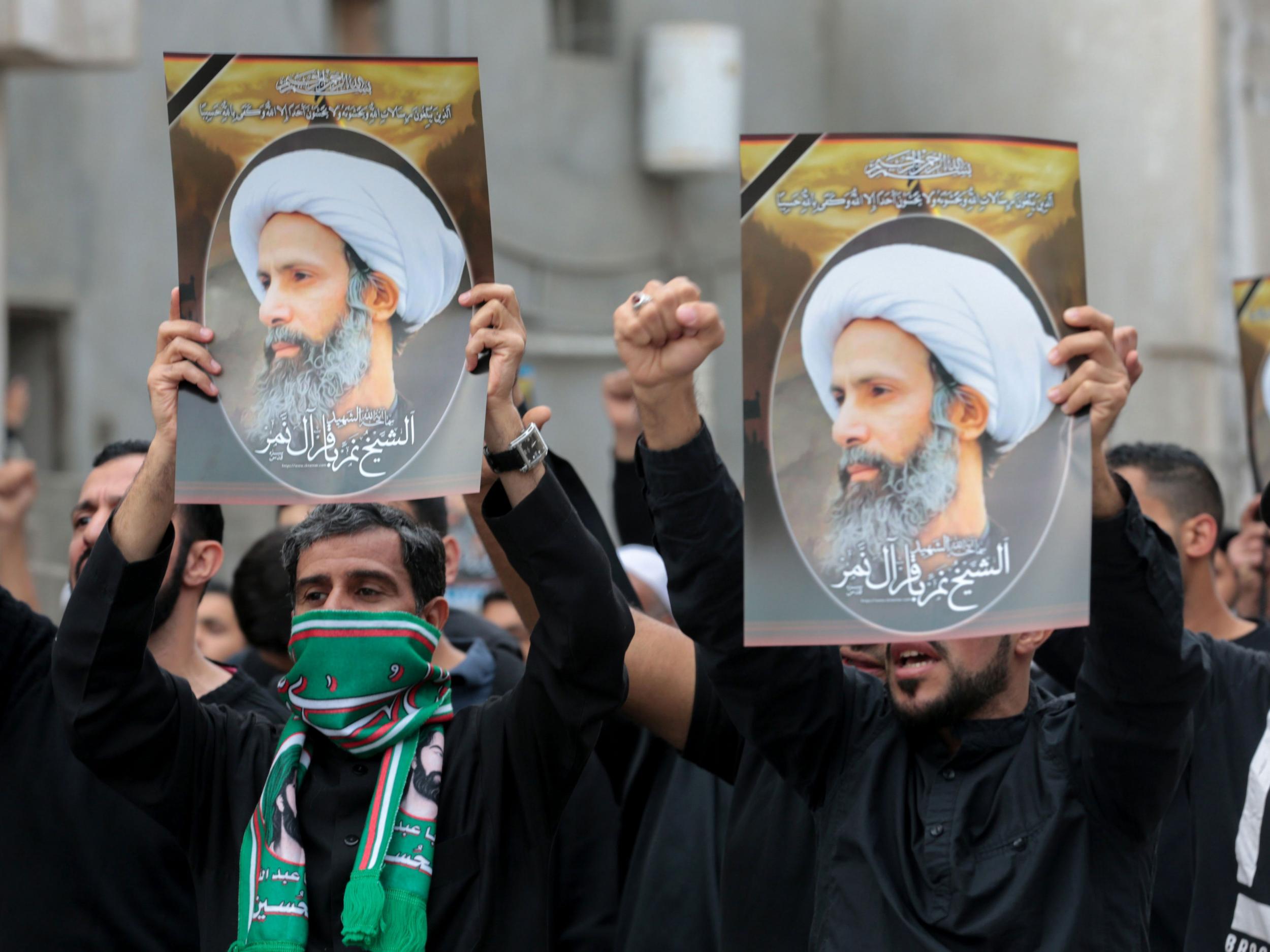 Saudi Shiite men hold placards bearing portraits of prominent Shiite Muslim cleric Nimr al-Nimr during a protest against his execution by Saudi authorities Getty