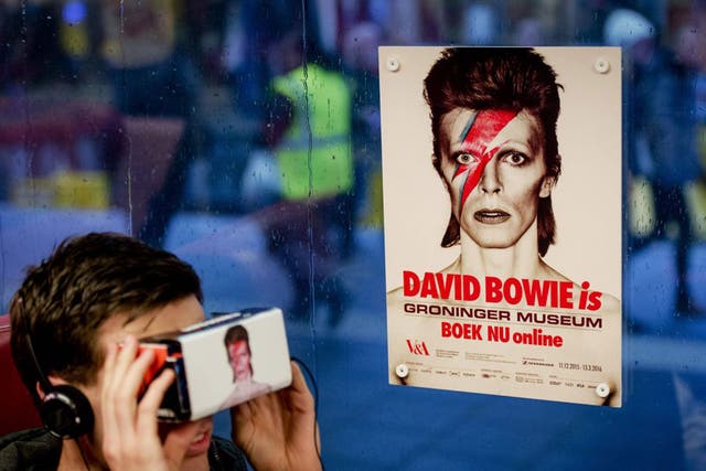 People take a virtual journey through the life of David Bowie on the train from Zwolle to Groningen, Holland, on Monday. Bowie correctly predicted the impact the internet would have on the music industry