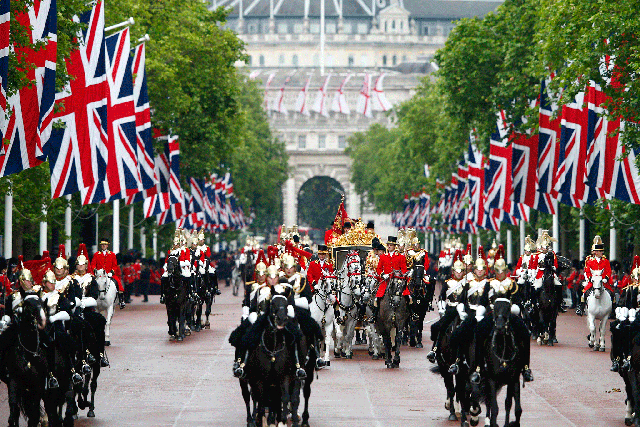 Britain's Queen Elizabeth, accompanied by Prince Philip, travel down the Mall in the new Diamond Jubilee in June 2014