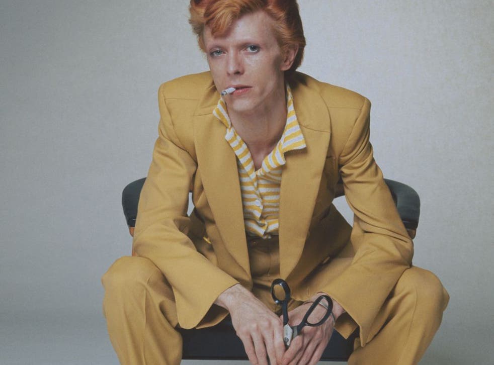 David Bowie with dyed red hair and a yellow suit, circa 1974.