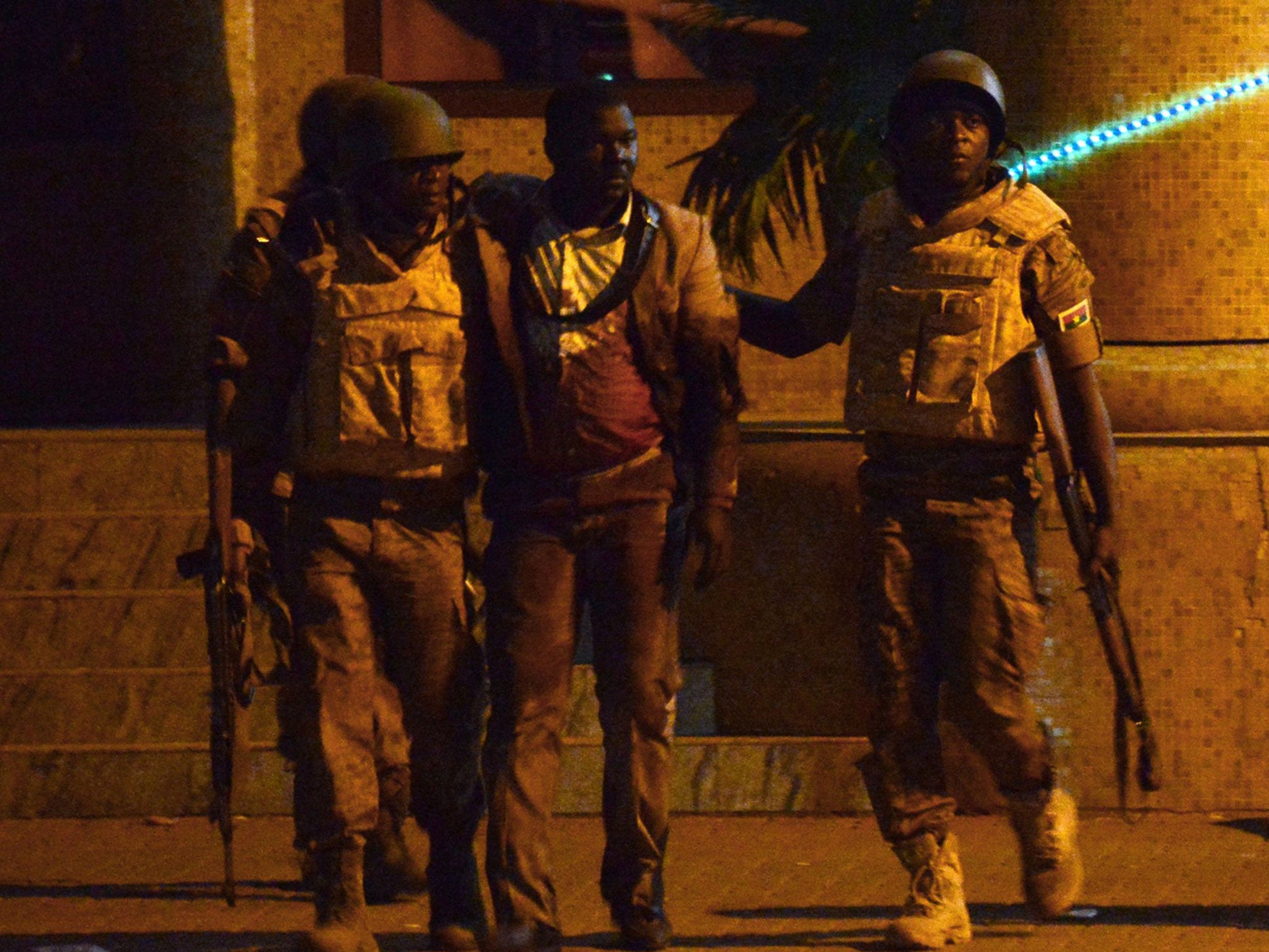 Burkina Faso's soldiers evacuate an injured man (3rd L) from the Splendid hotel during an attack on both the hotel and a restaurant by Al-Qaeda linked gunmen late on January 15, 2016.