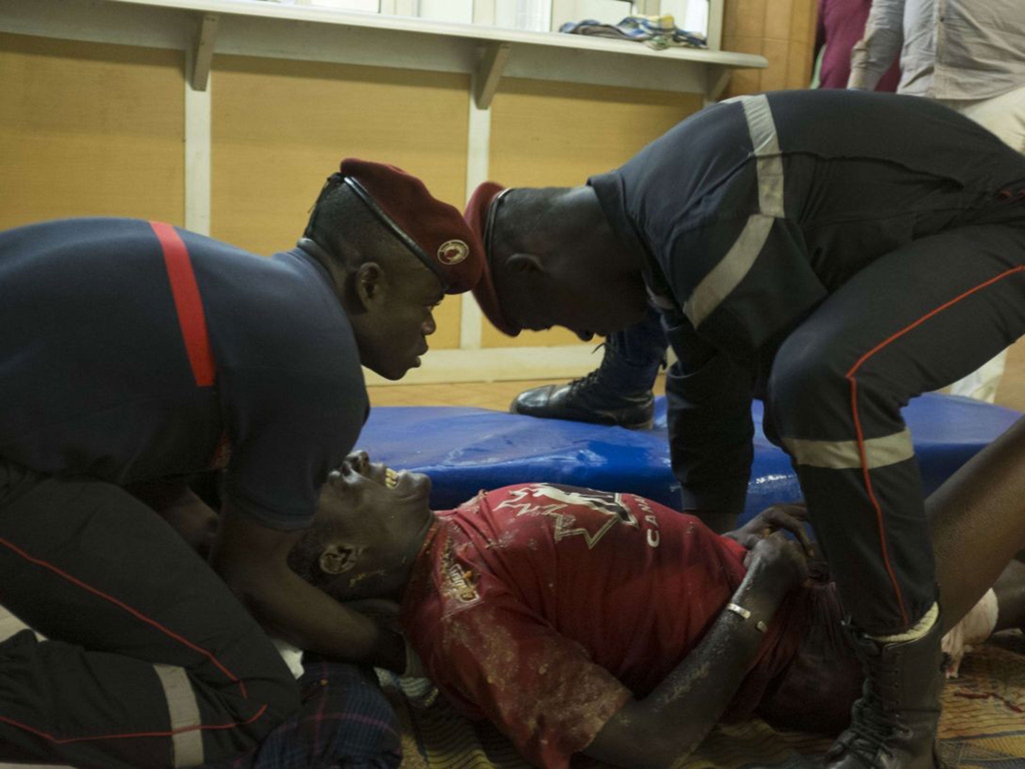 Paramedics tend to a wounded man in the surrounding of the hotel Splendide and the cafe Cappuccino during the attack on January 15, 2016.