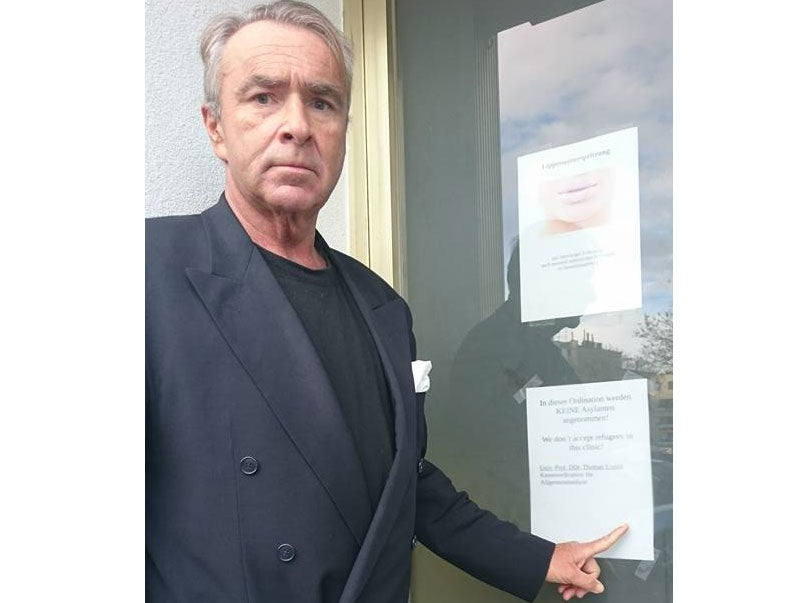 Dr. Thomas Unden with the sign on his practice refusing care to asylum seekers.