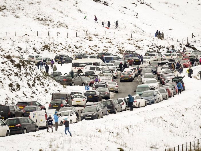 Slow moving traffic and vehicles parked on the A470, near Pen y Fan, Brecon, as people travel to the Brecon Beacons National Park to enjoy the recent snowfall