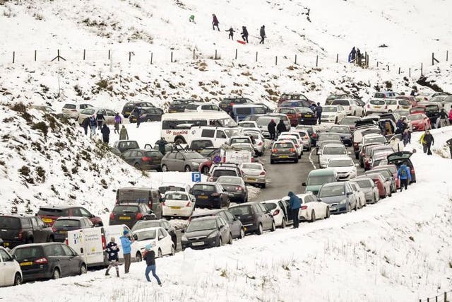 Slow moving traffic and vehicles parked on the A470, near Pen y Fan, Brecon, as people travel to the Brecon Beacons National Park to enjoy the recent snowfall