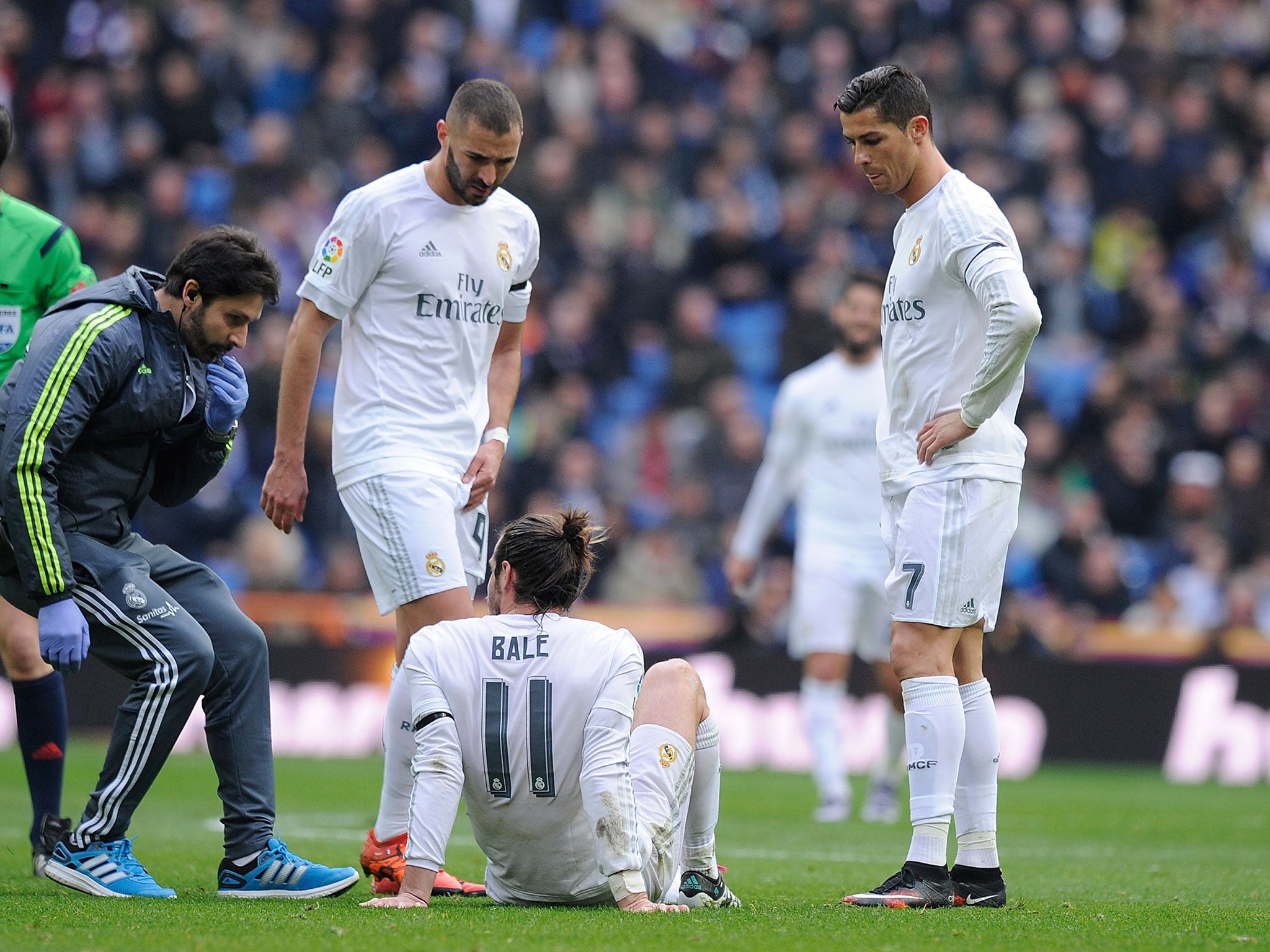 Gareth Bale of Real Madrid lies injured beside Cristiano Ronaldo and Karim Benzema