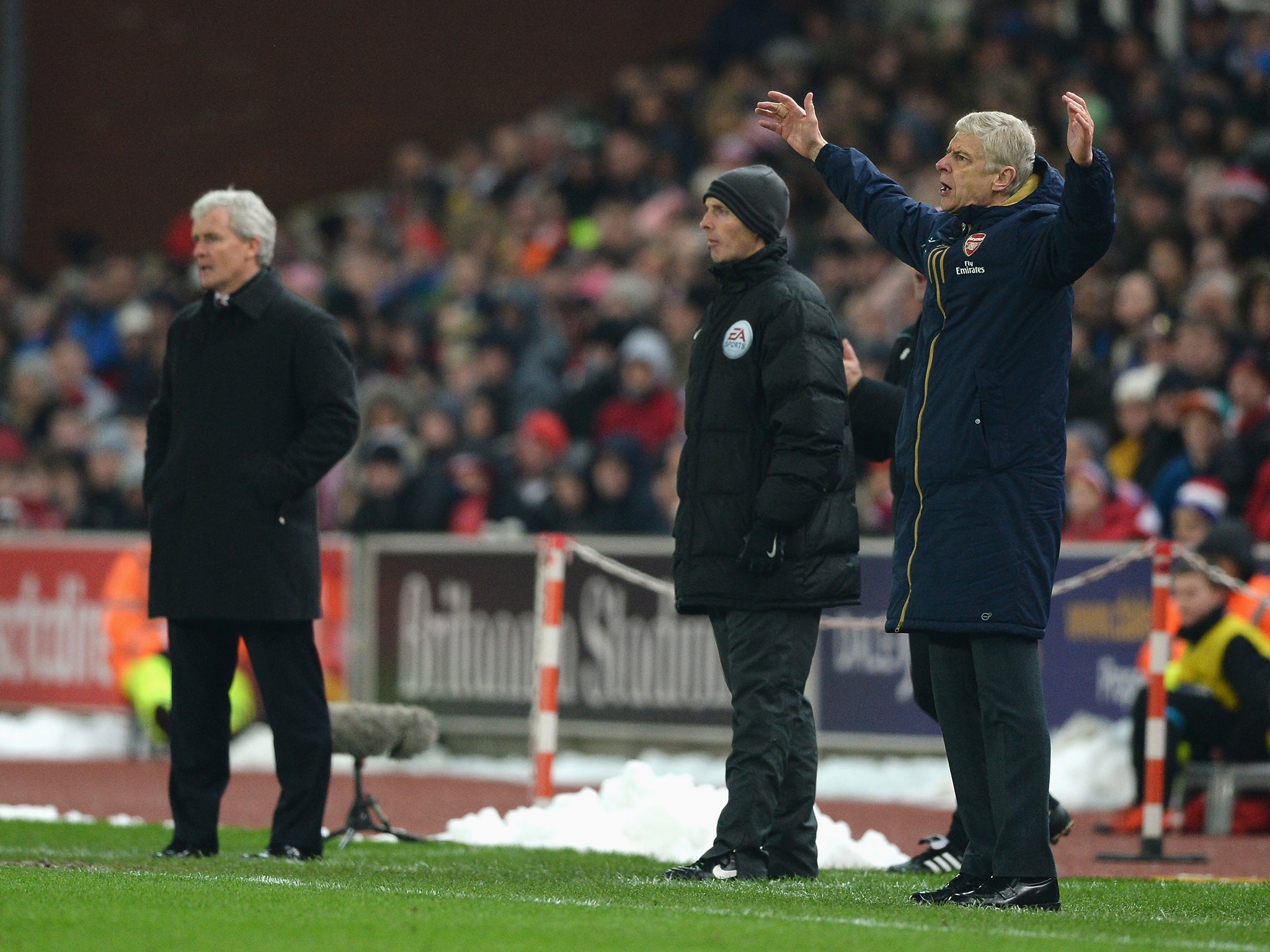 Arsene Wenger reacts on the touchline with Mark Hughes in view