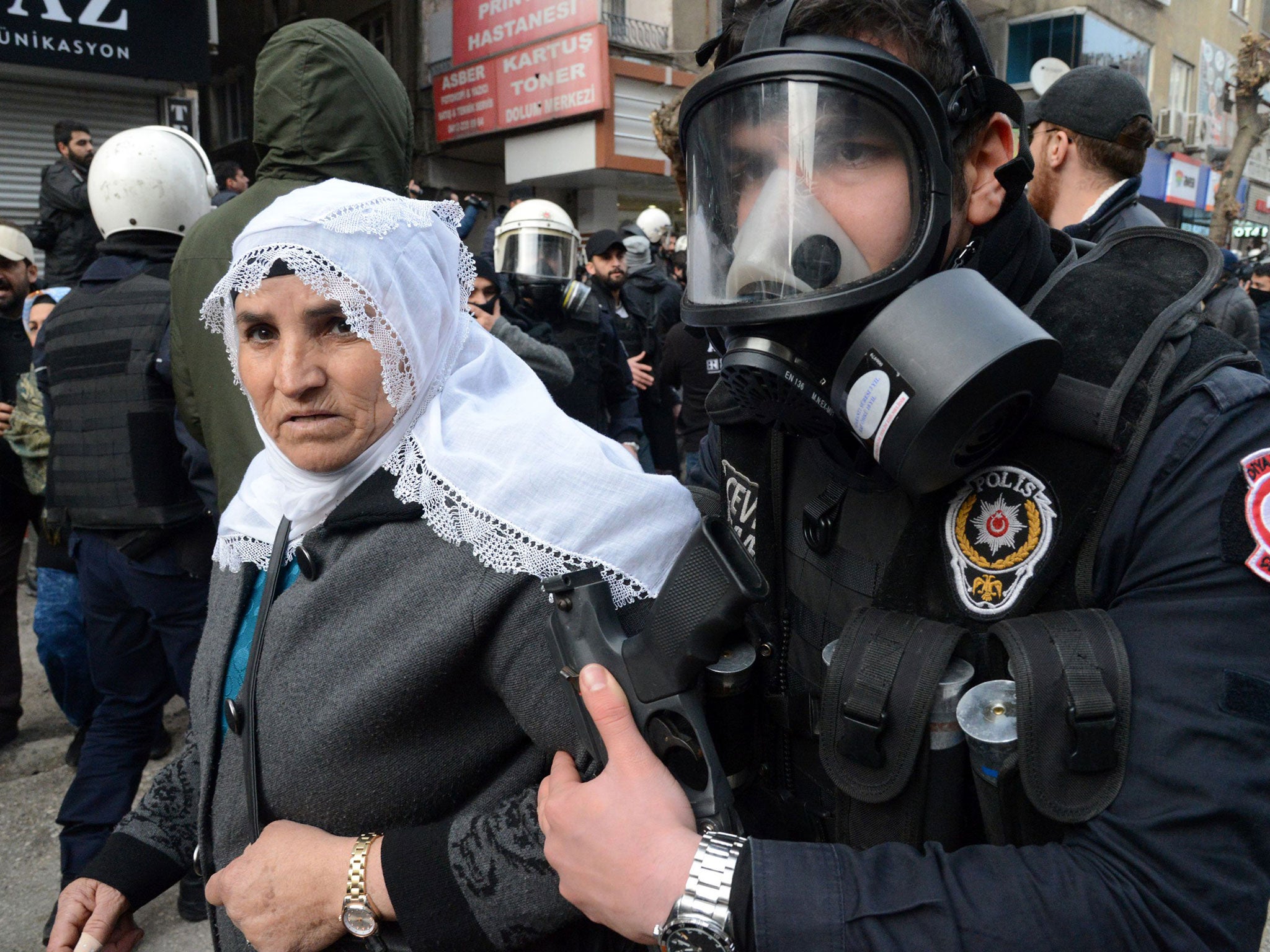 Turkish riot police detain a woman as protesters demonstrate against the curfew in the Sur district of Diyarbakir in south-eastern Turkey