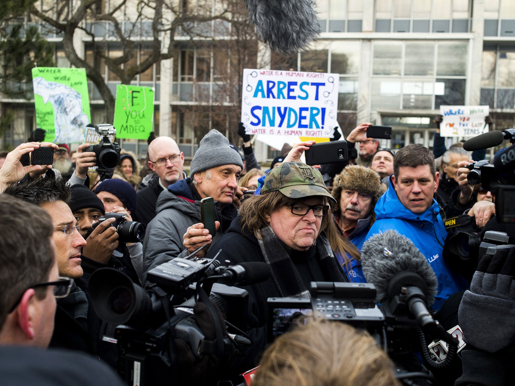 Michael Moore, centre, is part of a movement calling for the arrest of Michigan’s Governor