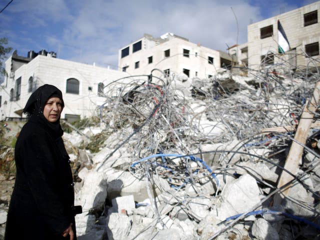 The mother of Palestinian Muhannad Halabi stands next to her house after it was demolished by Israeli troops in the village of Surda, near the West Bank city of Ramallah