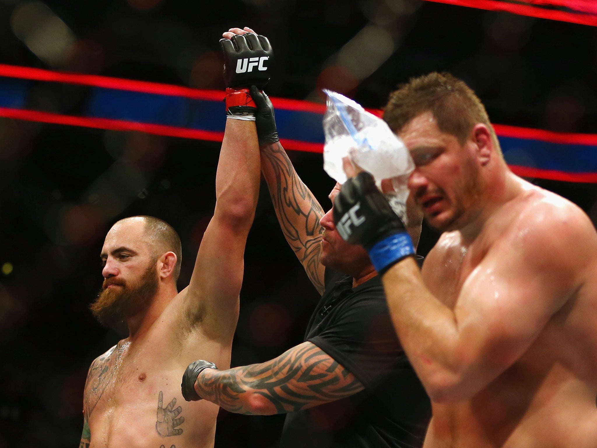 Browne's hand is raised in victory as Mitrione ices his right eye