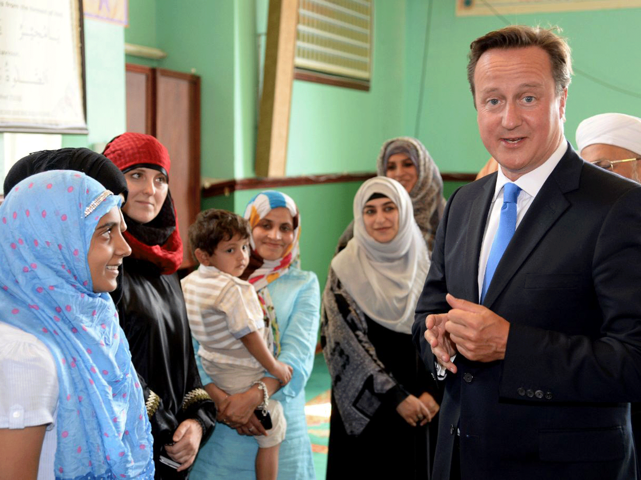 Young Muslim women speak to David Cameron at the Jamia Masjid mosque in Manchester in 2013. He has said Muslim women who cannot speak English will be 'susceptible' to Isis