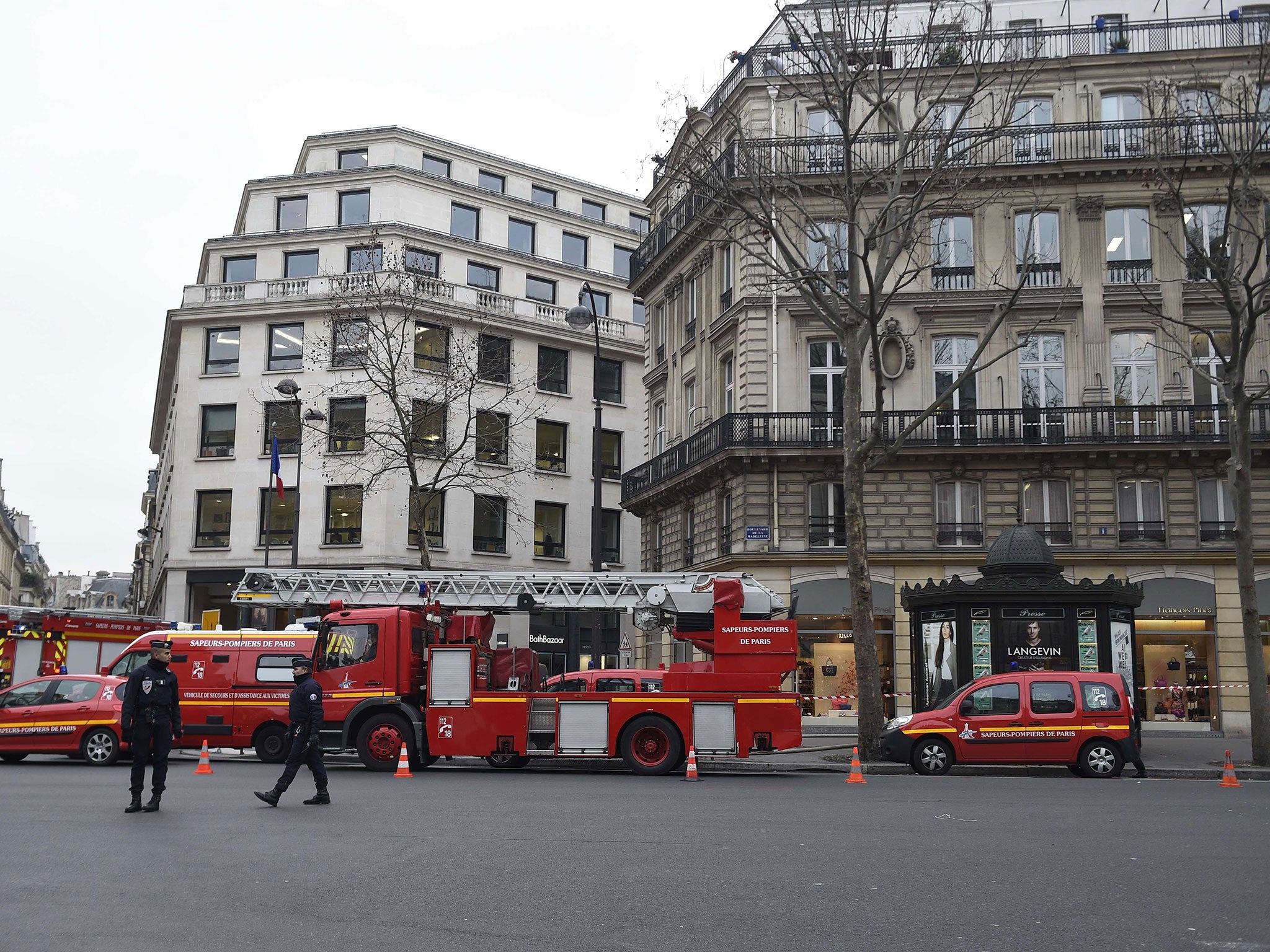 French police officers stand guard next to fire trucks parked near the Ritz Hotel in Paris after a fire broke out at the landmark hotel on January 19, 2016