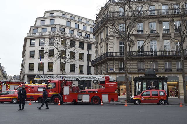 French police officers stand guard next to fire trucks parked near the Ritz Hotel in Paris after a fire broke out at the landmark hotel on January 19, 2016