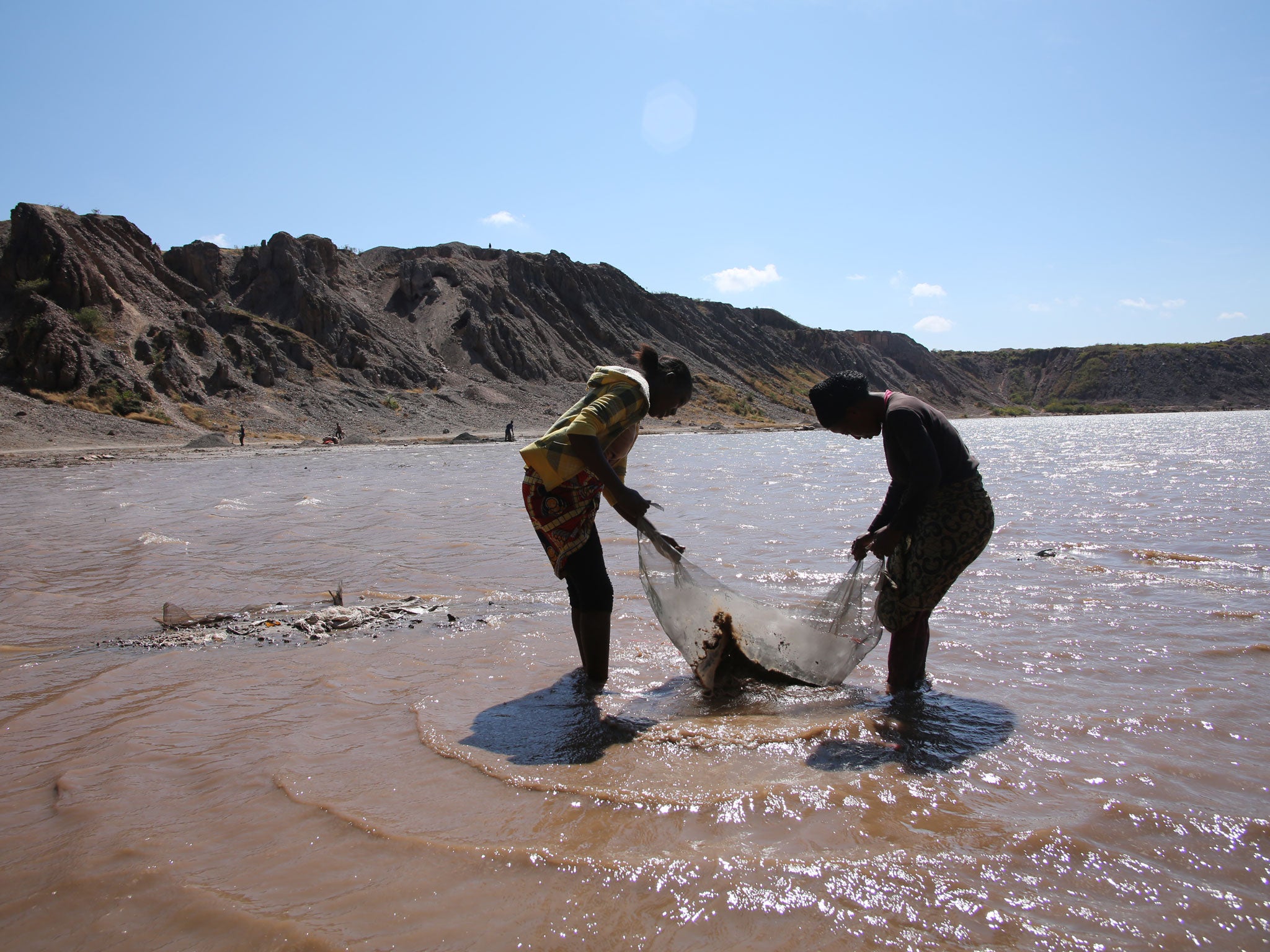 Women wash mineral ore in Lake Malo, Kapata on the outskirts of Kolwezi,DRC. One woman told researchers that it was very difficult working long daysfrom 6am until 6pm in the sun with no cover and no shade, May 2015