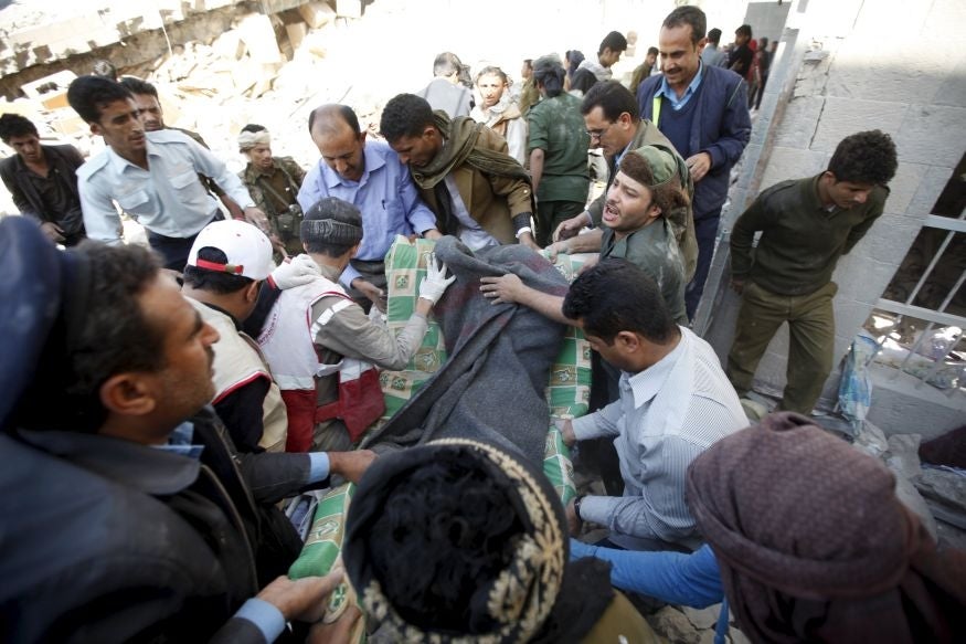 Medics attend to the aftermath of an air strike on a police station in Yemen's capital Sanaa
