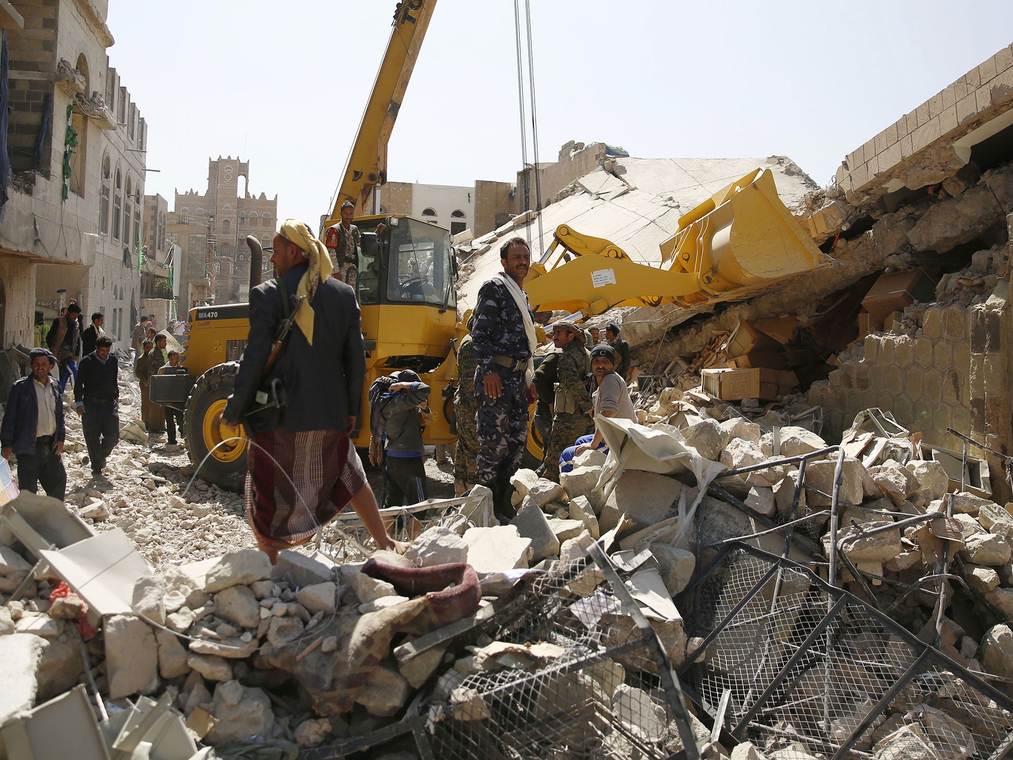 Policemen search for survivors at the site of a Saudi-led airstrike on the police headquarters in Sanaa