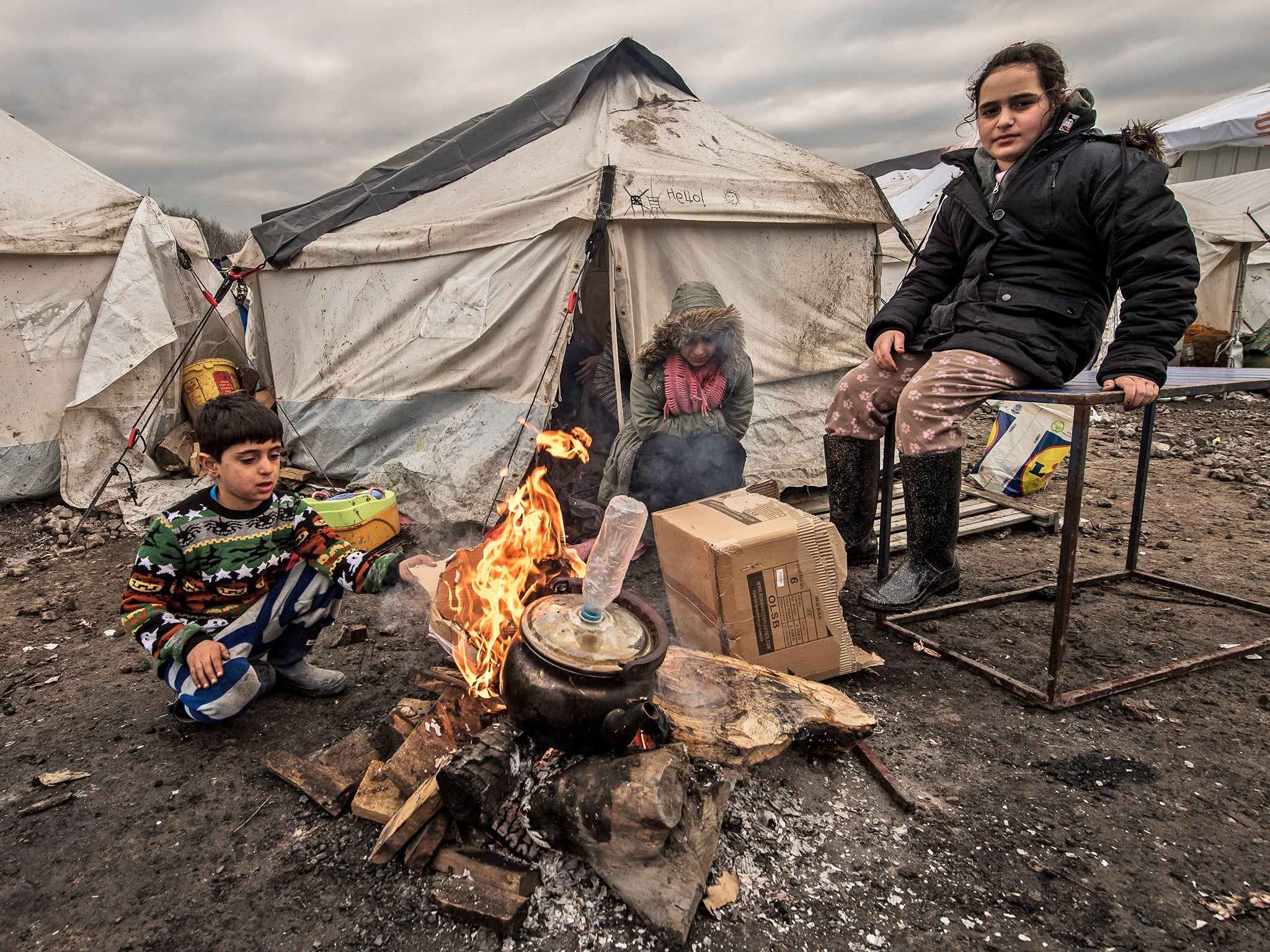 Young refugees try to keep warm at a refugee camp near Calais on Wednesday