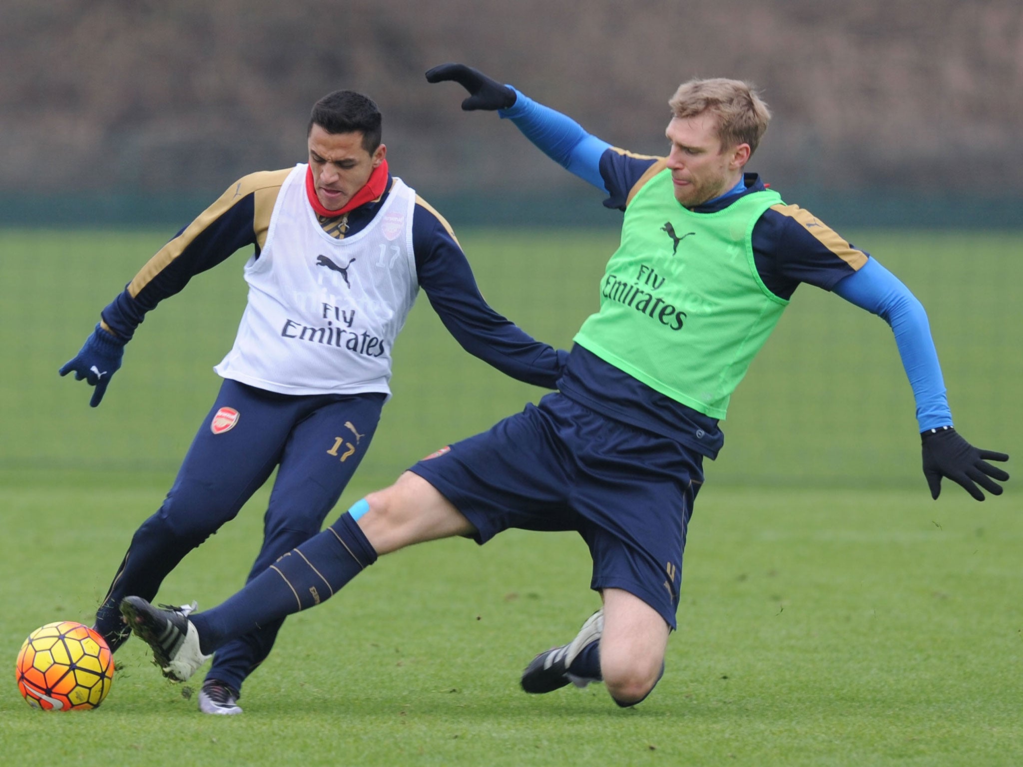 Alexis Sanchez, left, is challenged by Per Mertesacker during training