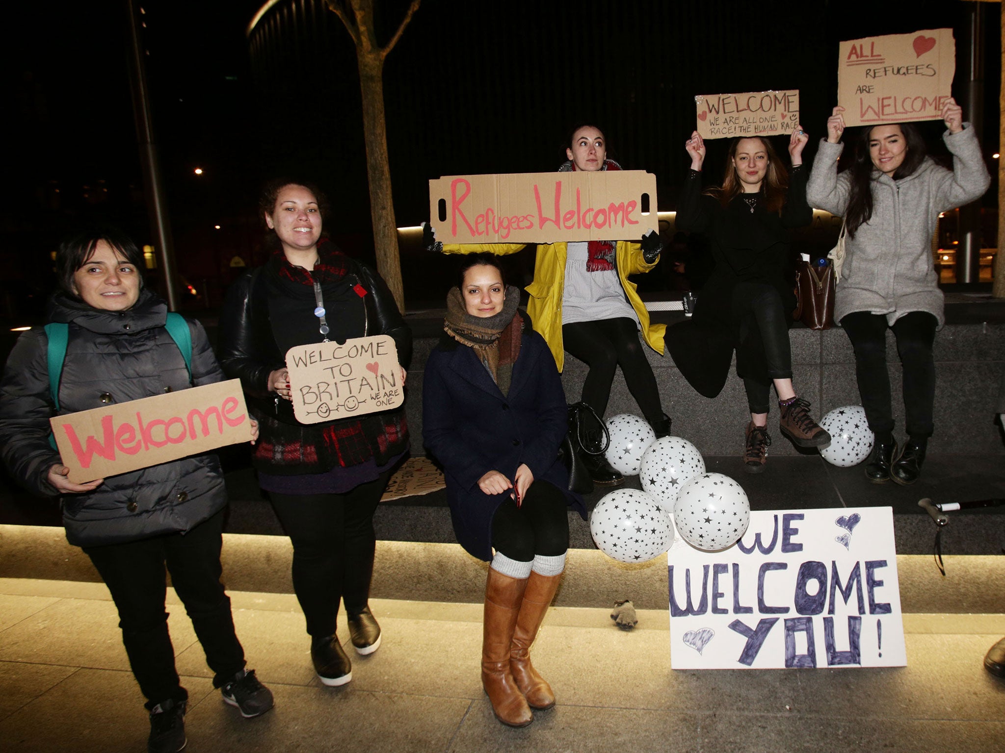 Supporters and well-wishers at St. Pancras International station in London wait to greet the arrival of four Syrian refugees