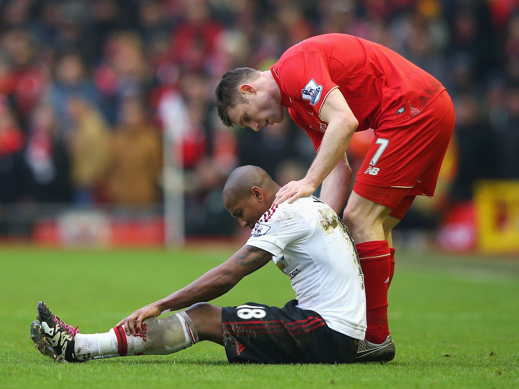 Ashley Young of Manchester United reacts after a challenge by James Milner of Liverpool during the Barclays Premier League match between Liverpool and Manchester
